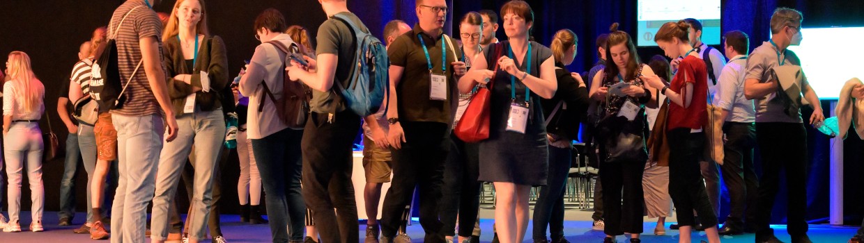 Besucherinnen und Besucher stehen und unterhalten sich vor dem Eingang zu Saal 4 auf der OTWorld. Besucherinnen und Besucher stehen und unterhalten sich vor dem Eingang zu Saal 4 auf der OTWorld.