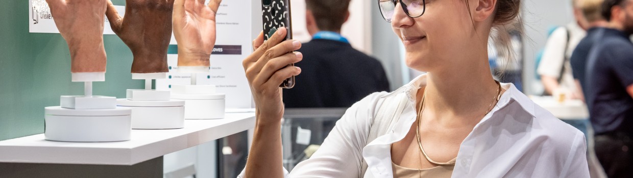 Eine Besucherin fotografiert detailgetreue prothetische Handmodelle auf der OTWorld. Eine Besucherin fotografiert detailgetreue prothetische Handmodelle auf der OTWorld.