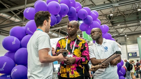 Internationale Fachgespräche auf der OTWorld – Austausch über Innovationen vor einer kreativen Kulisse aus lila Luftballons. Internationale Fachgespräche auf der OTWorld – Austausch über Innovationen vor einer kreativen Kulisse aus lila Luftballons.