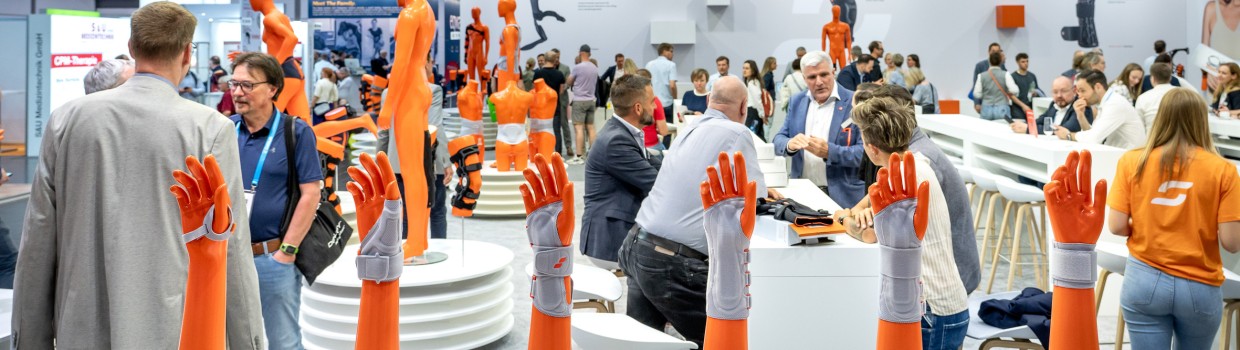 Ein Tisch mit sechs Handmodellen, die unterschiedliche Handgelenksbandagen zeigen. 
