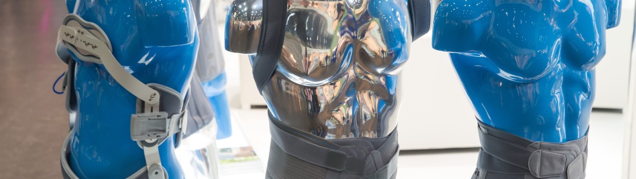 Three blue torso mannequins wearing orthopedic back and torso braces at a trade fair booth. Three blue torso mannequins wearing orthopedic back and torso braces at a trade fair booth.