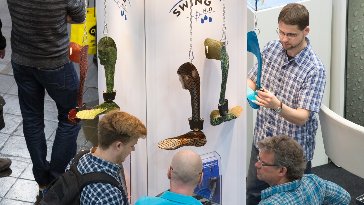 Trade fair visitors look at a system ankle joint. Trade fair visitors look at a system ankle joint.