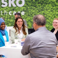 Conversation situation at the trade fair stand: six people laughing at each other. Conversation situation at the trade fair stand: six people laughing at each other.