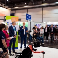 Conversation situation: A man with a microphone speaks in front of numerous trade fair visitors. Conversation situation: A man with a microphone speaks in front of numerous trade fair visitors.
