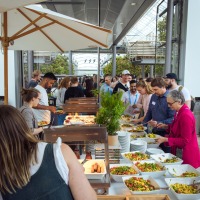 People standing at a buffet. People standing at a buffet.