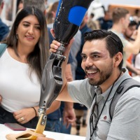 A person holds a prosthetic leg in their hand. A person holds a prosthetic leg in their hand.