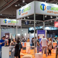 Well-attended trade fair stand, above it in large letters: “OTWorld start-ups”. Well-attended trade fair stand, above it in large letters: “OTWorld start-ups”.