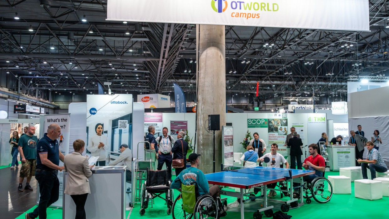 Wheelchair users play table tennis at the OTWorld campus while visitors gather information at booths focused on education and young talent promotion