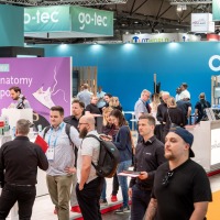 Visitors stroll through OTWorld past the colorful go-tec stand, while others gather information at the stations Visitors stroll through OTWorld past the colorful go-tec stand, while others gather information at the stations