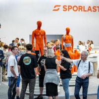 There is a lot of activity at the SPORLASTIC booth – visitors and professionals engage in conversations and examine bright orange demonstration models for orthopaedic applications. There is a lot of activity at the SPORLASTIC booth – visitors and professionals engage in conversations and examine bright orange demonstration models for orthopaedic applications.