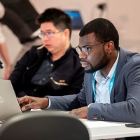 A man in business attire looks intently at his laptop. A man in business attire looks intently at his laptop.