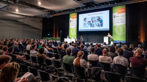 Congress situation: A lecture is taking place on the stage in the congress hall, with a large audience sitting in front of it.